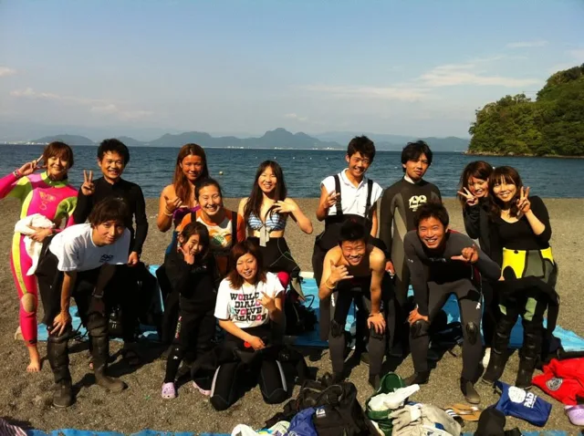 海辺で記念撮影するBIG BLUEの参加者（2012-2013年）