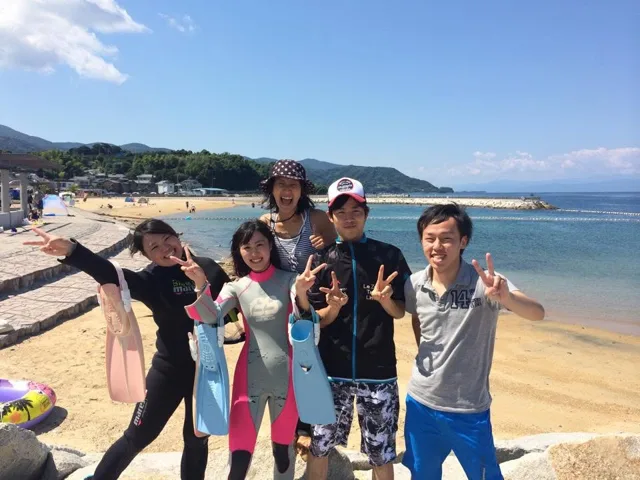 海辺で記念撮影するBIG BLUEの参加者（2014年）