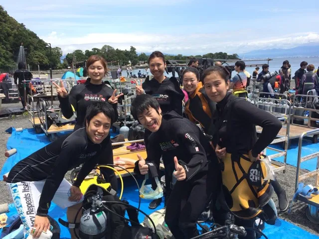 海辺で記念撮影するBIG BLUEの参加者（2015年）