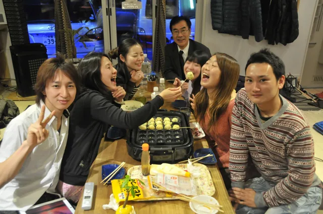 室内で飲み物を持って集まる参加者（2012-2013年）