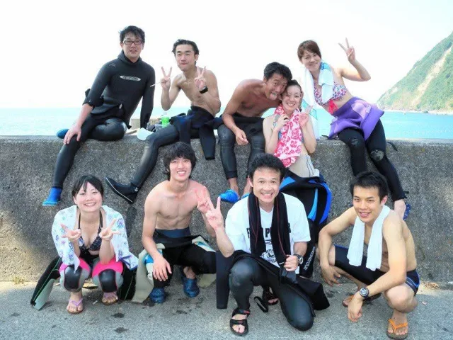 海辺で記念撮影するBIG BLUEの参加者（2012-2013年）
