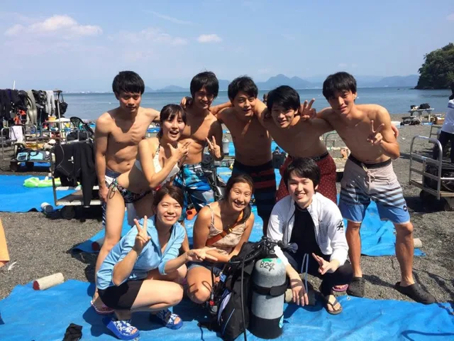 海辺で記念撮影するBIG BLUEの参加者（2015年）