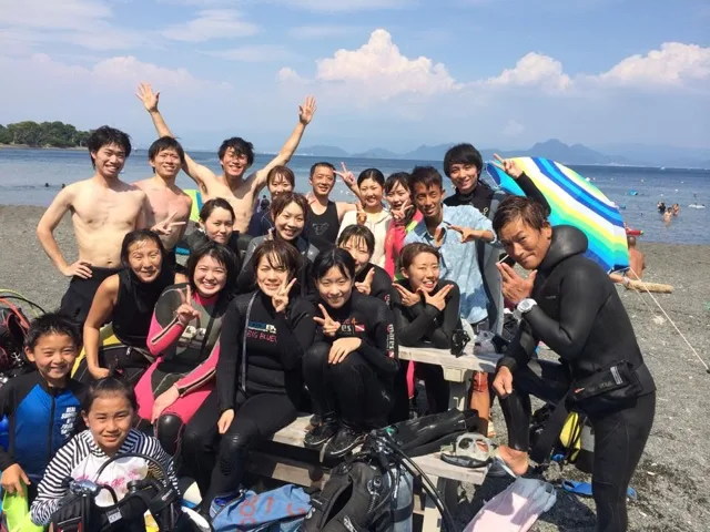 海辺で記念撮影するBIG BLUEの参加者（2015年）