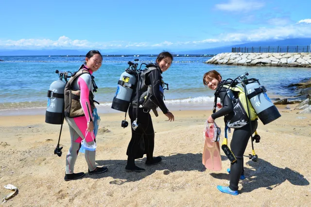 砂浜を歩くダイビング器材姿の参加者（2014年）