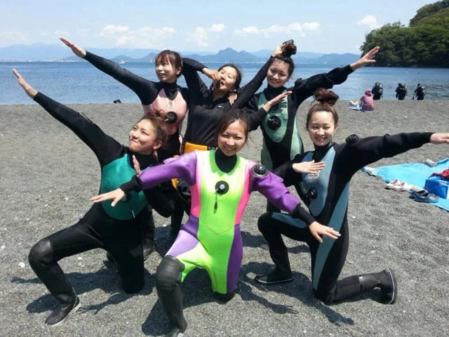 海辺で記念撮影するBIG BLUEの参加者（2014年）