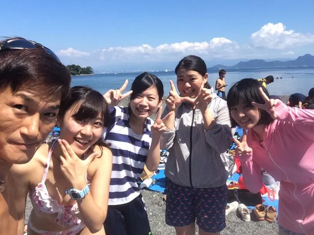 海辺で記念撮影するBIG BLUEの参加者（2015年）