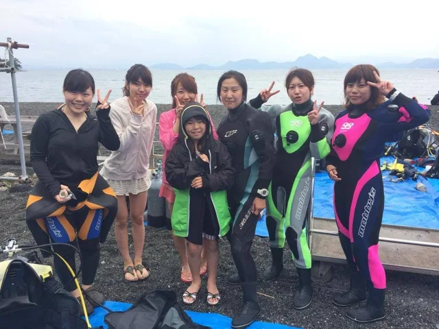海辺で記念撮影するBIG BLUEの参加者（2014年）