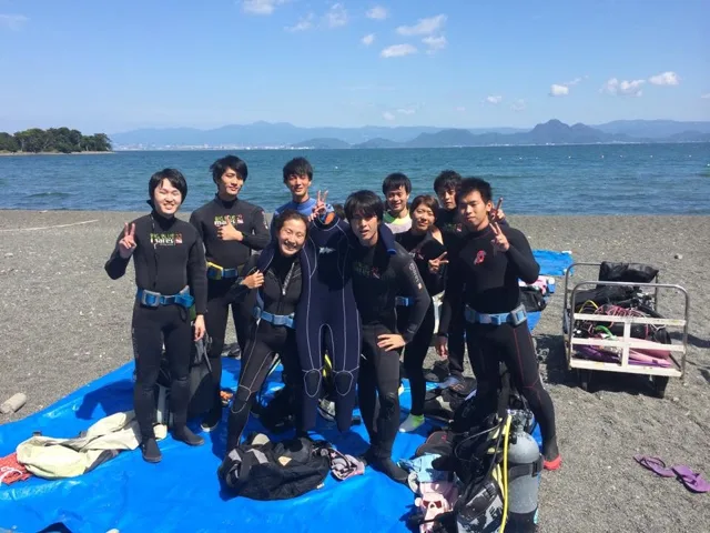 海辺で記念撮影するBIG BLUEの参加者（2015年）