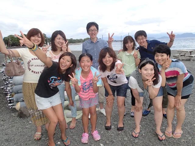海辺で記念撮影するBIG BLUEの参加者（2012-2013年）