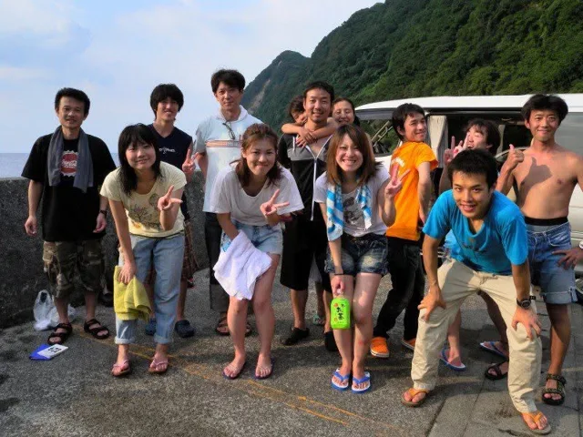 海辺で記念撮影するBIG BLUEの参加者（2012-2013年）