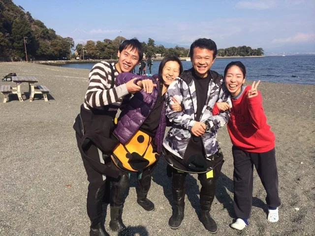 海辺で記念撮影するBIG BLUEの参加者（2014年）