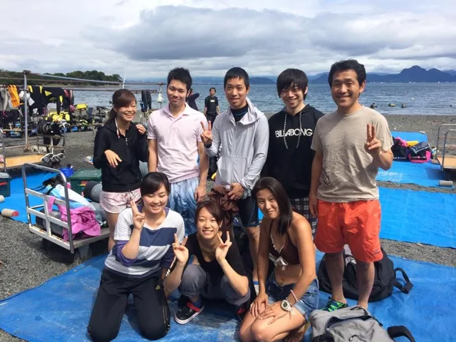 海辺で記念撮影するBIG BLUEの参加者（2015年）