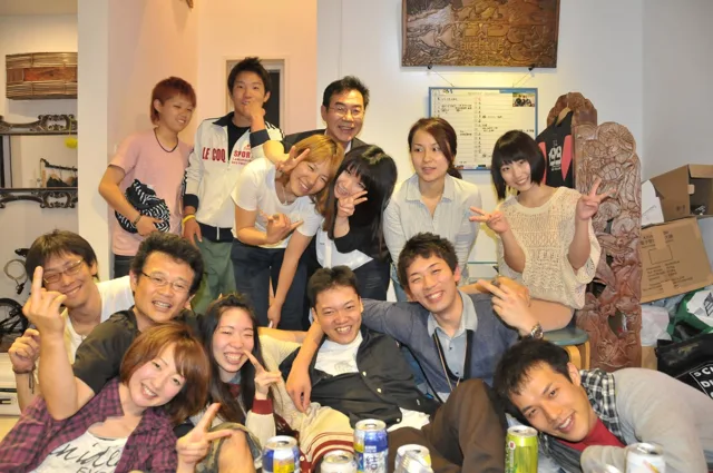 室内で食事を囲んで記念撮影する参加者（2012-2013年）