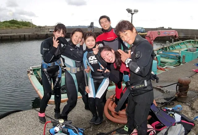 海辺で記念撮影するBIG BLUEの参加者（2015年）