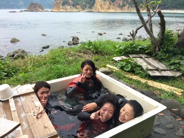 海を背景に木製のベンチでくつろぐ参加者（2015年）