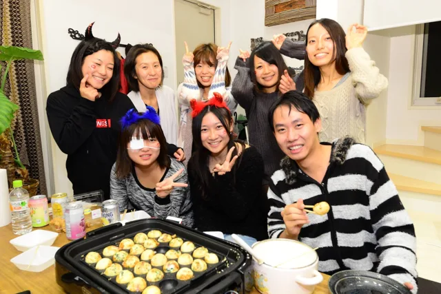 室内でたこ焼きを囲む参加者（2012-2013年）
