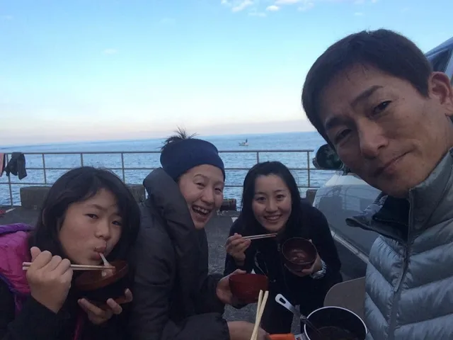海辺で記念撮影するBIG BLUEの参加者（2015年）