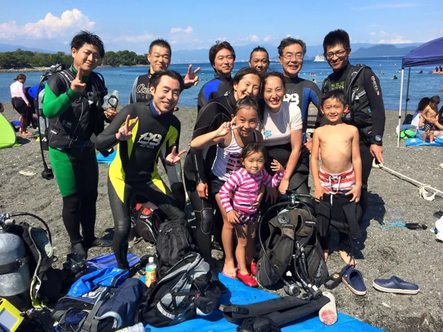 海辺で記念撮影するBIG BLUEの参加者（2015年）