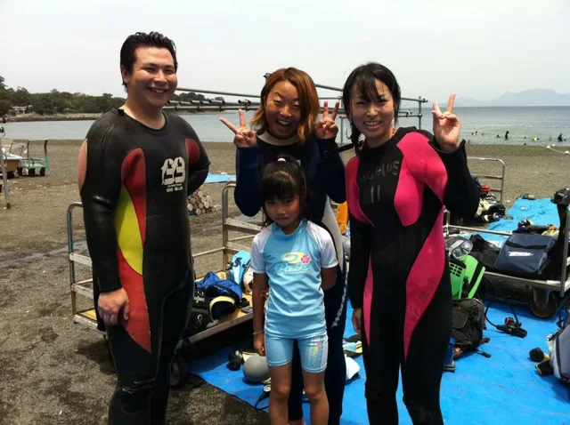 伊豆・大瀬崎でのダイビング：海辺でウェットスーツ姿で並ぶ参加者