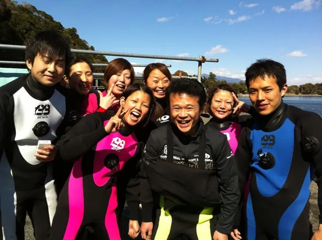 海辺で器材を着けたダイバーの集合写真