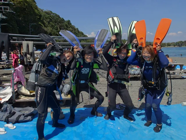フィンを掲げるダイビングの参加者