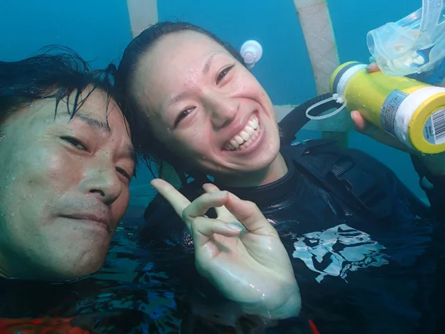 水中で記念撮影するダイバー