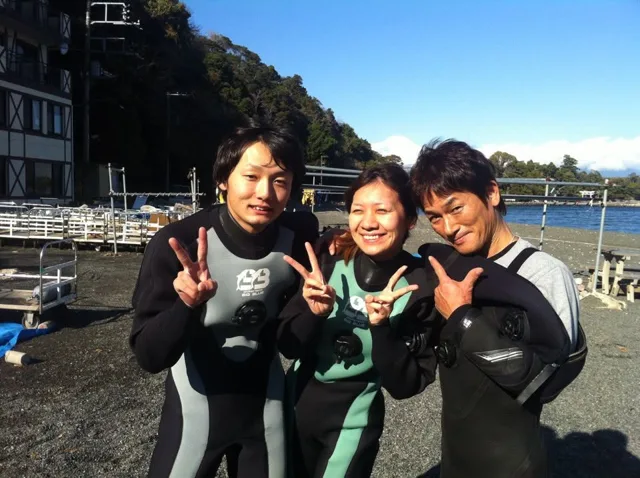 伊豆・大瀬崎でのダイビング：海辺でウェットスーツ姿で並ぶ参加者