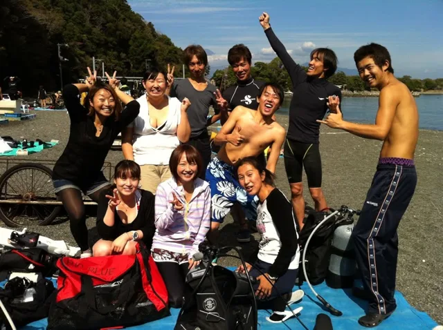 伊豆・大瀬崎でのダイビング：海辺で並ぶ参加者の集合写真