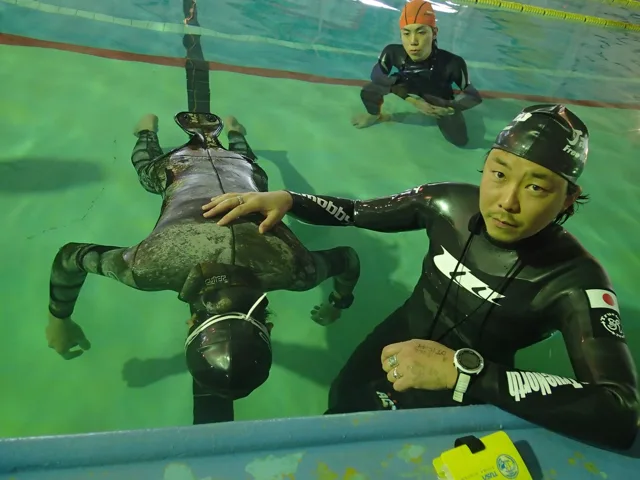 プールで潜水する参加者
