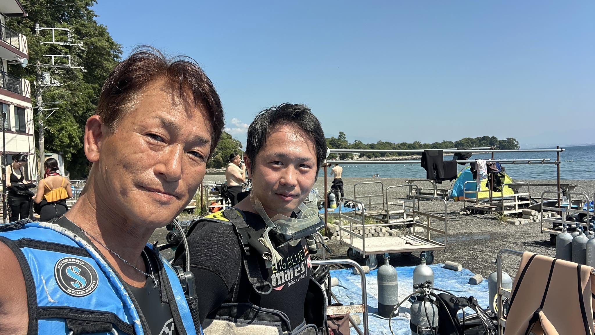 2025年9月1日(投稿日) / 伊豆・大瀬崎 / ダイビング / 伊豆・大瀬崎でのダイビング。海辺でダイビング器材を着けた2人の参加者