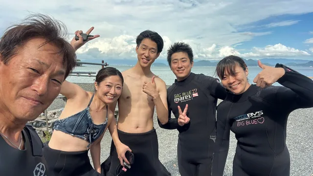 伊豆・大瀬崎でのダイビング：海辺でポーズを取る5人の参加者