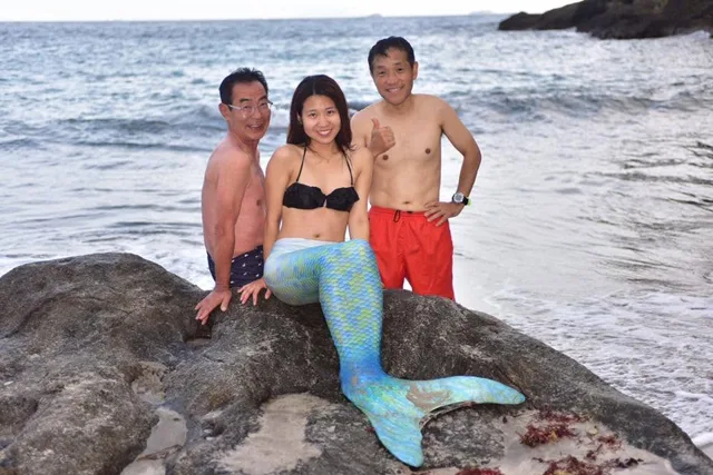 海辺で人魚の衣装を着た参加者