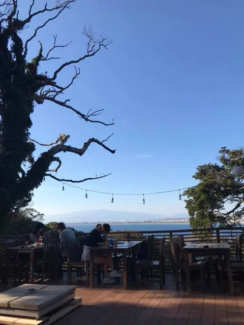 海を望む木陰のテラスと休憩する人々（場所未確認）