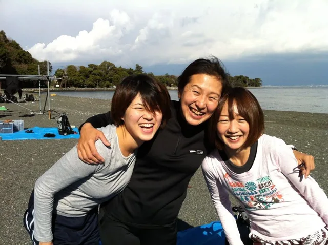 伊豆・大瀬崎でのダイビング：大瀬崎の海辺で記念撮影する3人のダイビング参加者