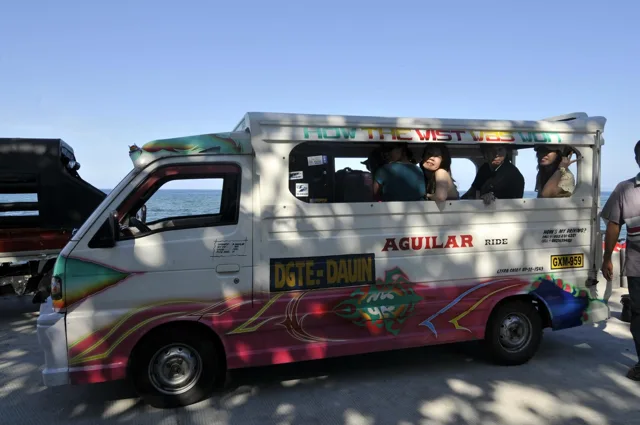 海沿いで乗り合い車に乗って移動する仲間（ダイビングツアー中と推定）