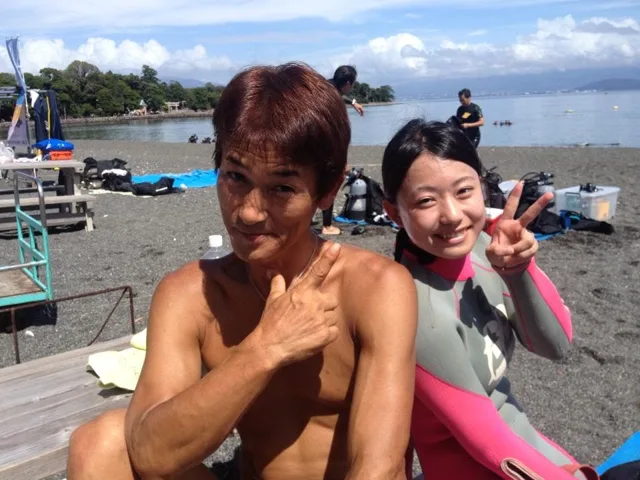 伊豆・大瀬崎でのダイビング：大瀬崎の海辺で記念撮影する2人のダイビング仲間