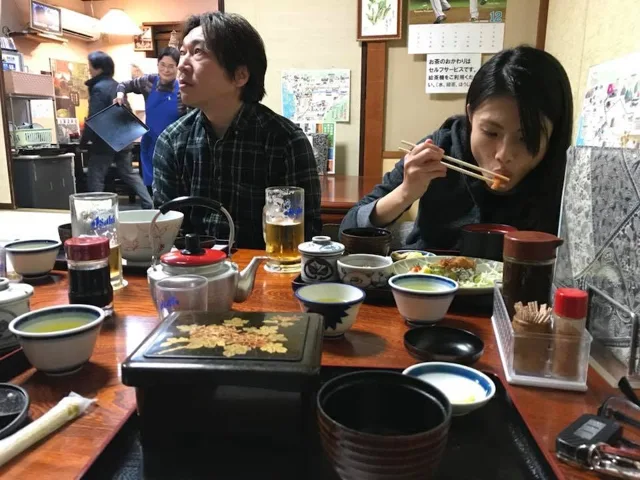 飲食店名未確認（雲見ツアーの元アルバム）での雲見ダイビングツアー中に食事を楽しむ参加者