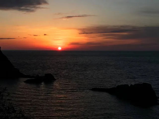 伊豆・雲見でのダイビング：雲見ダイビングの日に見た海に沈む夕日と海岸の岩