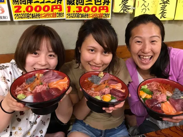 海のツアーの食事で海鮮丼を持って並ぶ3人の参加者(元アルバムから推定)