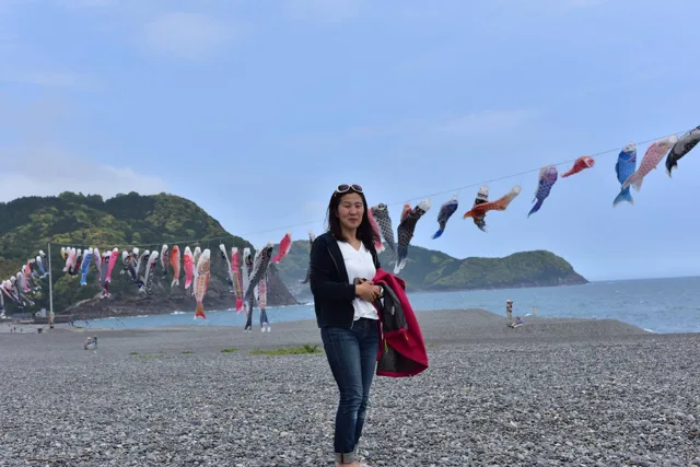 和歌山県・串本ツアー中（撮影地点未確認）での串本ダイビングツアー中、こいのぼりが並ぶ海岸で撮影する参加者