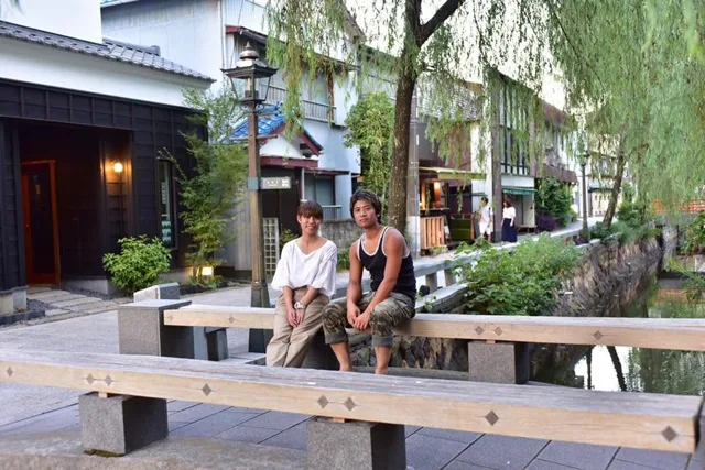静岡県下田市内（撮影地点未確認）での雲見ツアー中、下田市内の川沿いの橋に座る2人の参加者