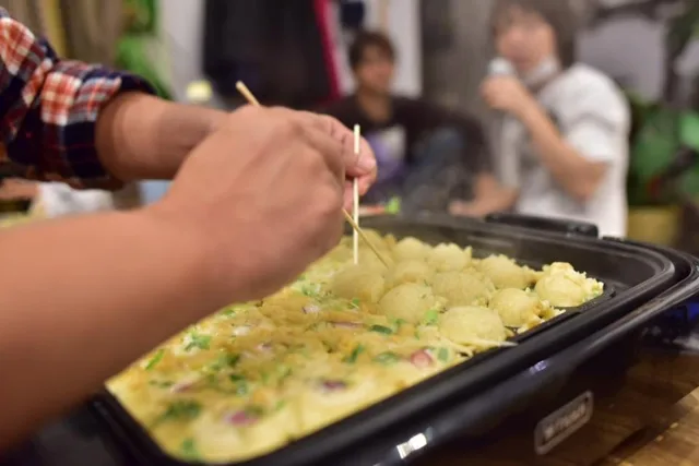 たこ焼きパーティーで鉄板の生地を返して作る様子