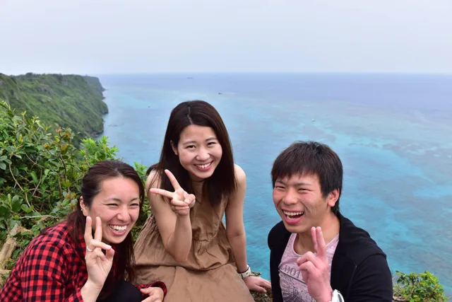 沖縄県・宮古島での宮古島ツアー中、海を見下ろす展望場所で並ぶ3人の参加者