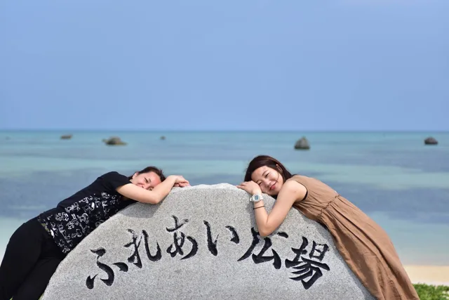 沖縄県・宮古島での宮古島ツアーで海辺のふれあい広場の石碑にもたれる参加者