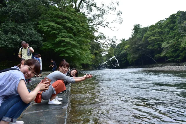 撮影場所未確認（越前ツアー中の観光）での越前ツアーの観光中、川辺で水に触れて過ごす参加者