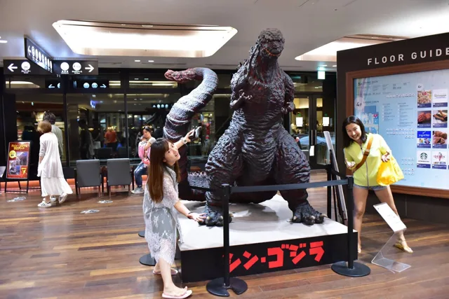 海ほたるのゴジラ像の横でポーズをとる参加者