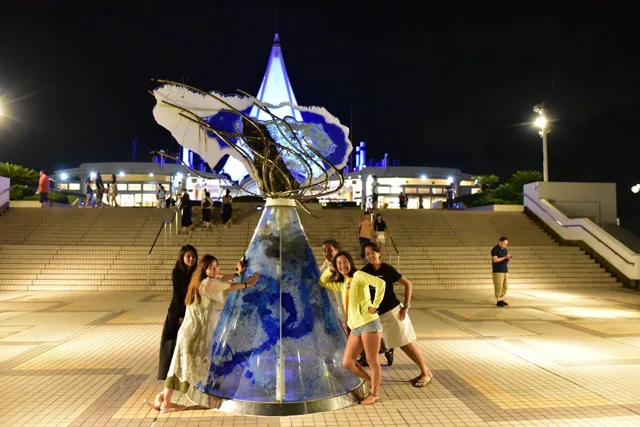 海ほたる展望エリアでの夜の海ほたるで青く光るモニュメントを囲む参加者
