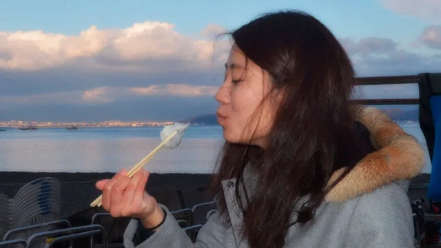 伊豆・大瀬崎でのダイビング：大瀬崎の海辺で餅を味わう参加者