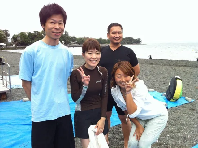 伊豆・大瀬崎でのダイビング：大瀬崎の海辺で並ぶ4人のダイビング参加者