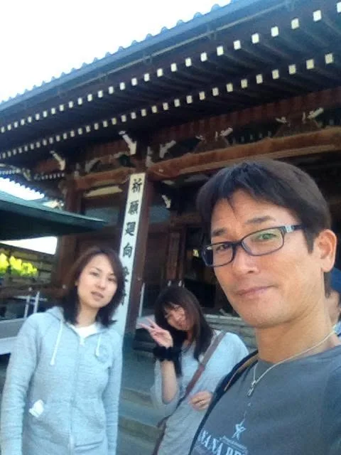 ツアー中の観光（寺院名未確認・推定）での寺院の門の前で撮影した3人の参加者。同日のツアー写真との連続性から推定、寺院名は未確認